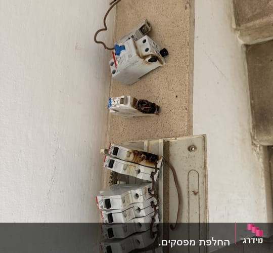 מפסקי חשמל שרופים על מדף בטון